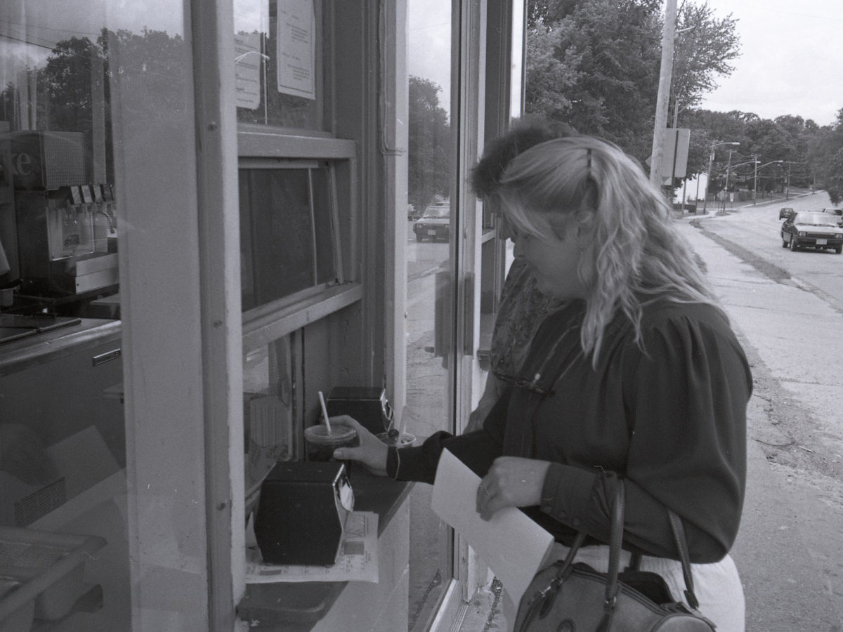 A customer at the walk-up window with the road behind her in 1994