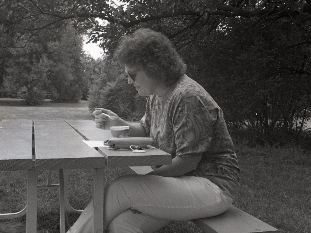 A customer enjoying custard at a picnic table under the trees in 1994